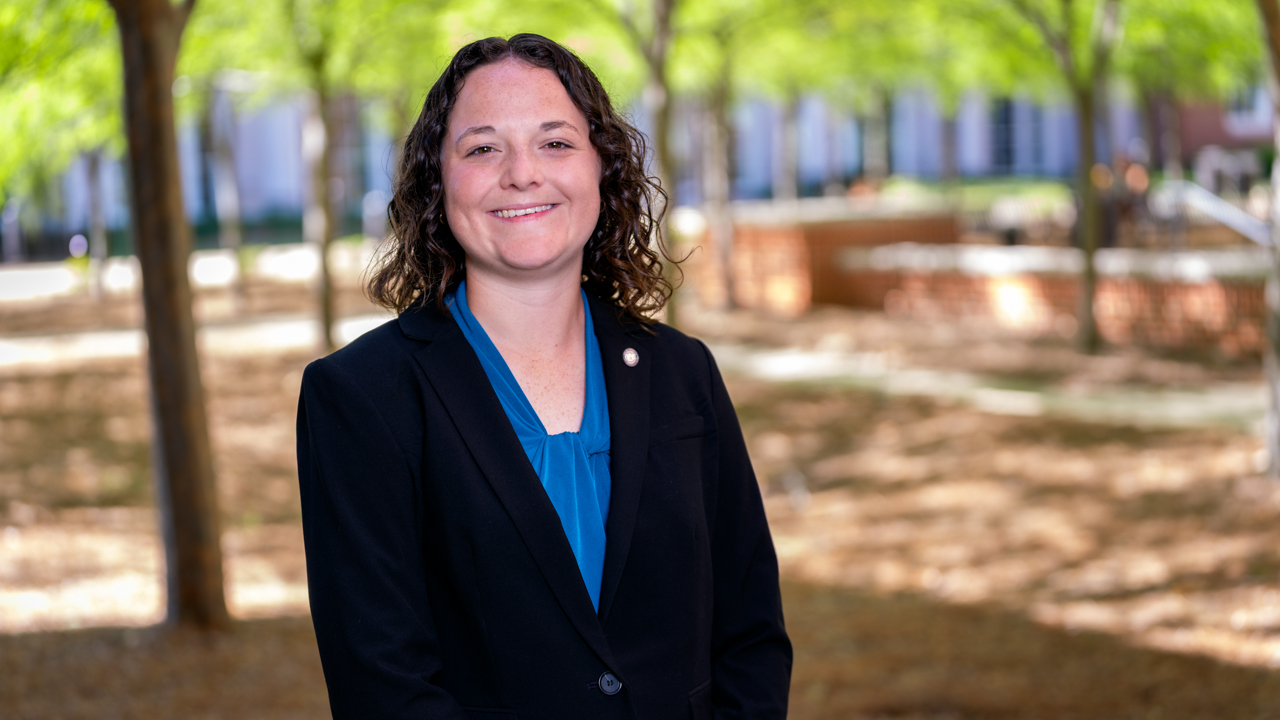headshot of robin weaver standing outside in a black suit withe a blue blouse